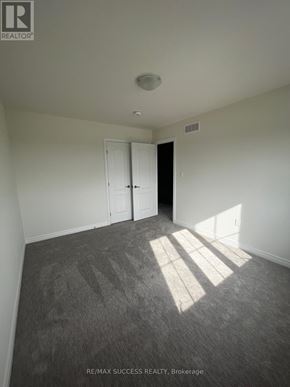 Hamilton townhouse for rent - A room with a carpeted floor and a door on the right side.