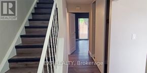 St. Catharines (Carlton/Bunting) townhouse for rent - A hallway with a staircase leading to a door.