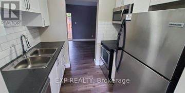 St. Catharines (Carlton/Bunting) townhouse for rent - A kitchen with a stainless steel refrigerator and a sink.