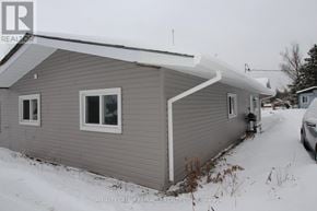 Kawartha Lakes (Ops) triplex for rent - A house with a grey siding and a white roof is shown in the image.