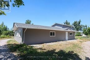 Kawartha Lakes (Ops) triplex for rent - A house with a grey siding and a white door is for sale.