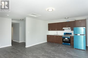 Kawartha Lakes (Ops) triplex for rent - A kitchen area with a blue fridge and a stove top oven.