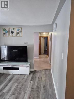Kitchener condo for rent - A living room with a television and a wooden floor.