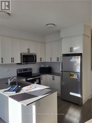 Waterloo townhouse for rent - A kitchen with white cabinets and a refrigerator.