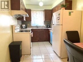 Oakville (Ga Glen Abbey) townhouse for rent - A kitchen with a white fridge and a black chair.