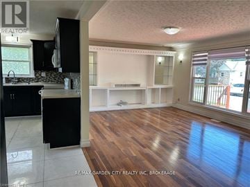 Welland (Lincoln/Crowland) house for rent - A kitchen with black cabinets and a wooden floor.