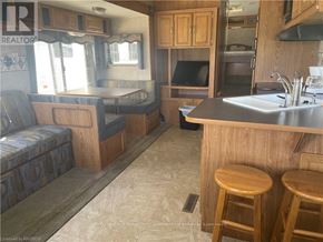 Northern Bruce Peninsula mobile home for rent - A kitchen area with a bar stool and a sink.