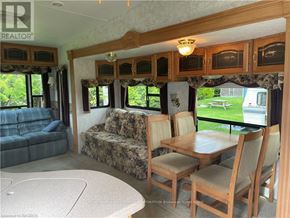 Northern Bruce Peninsula mobile home for rent - A living room with a couch, chairs, and a dining table.