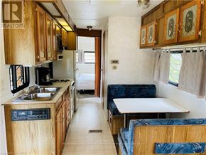 Northern Bruce Peninsula mobile home for rent - A kitchen area with a sink, stove and refrigerator.