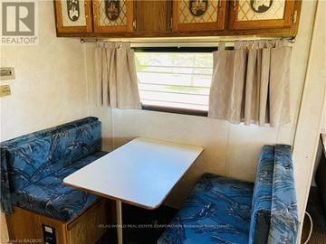 Northern Bruce Peninsula mobile home for rent - A small table and two couches are in a living room.
