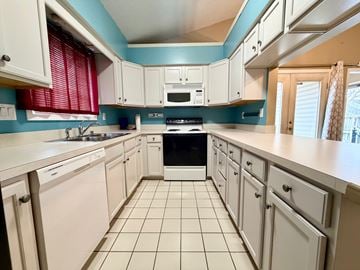 Louisville apartment for rent - A kitchen with white cabinets and a black stove top oven.