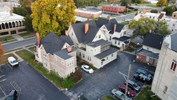Toledo apartment for rent - A large white building with a black roof sits in the middle of a parking lot.