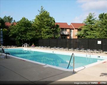 Annapolis apartment for rent - A swimming pool surrounded by a black fence and trees.