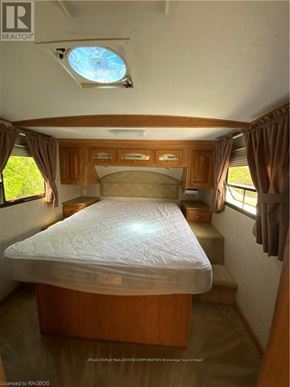 Northern Bruce Peninsula mobile home for rent - A bedroom with a bed, wooden cabinets, and a skylight.