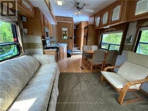 Northern Bruce Peninsula mobile home for rent - A living room with a couch and chairs is shown.