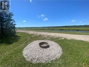 Northern Bruce Peninsula mobile home for rent - A tire surrounded by gravel sits in the middle of a grassy area.