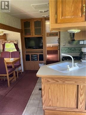 Northern Bruce Peninsula mobile home for rent - A kitchen with wooden cabinets and a white sink.