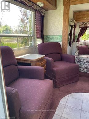 Northern Bruce Peninsula mobile home for rent - A living room with a couch, chair, and table.