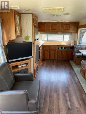Northern Bruce Peninsula mobile home for rent - A living room with wood floors and a grey couch.