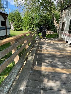 Northern Bruce Peninsula mobile home for rent - A wooden fence runs along the side of a concrete walkway.