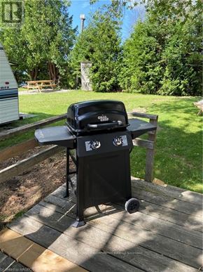 Northern Bruce Peninsula mobile home for rent - A black grill is on a wooden deck.