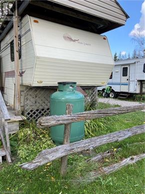 Northern Bruce Peninsula mobile home for rent - A green gas tank is in front of a camper.