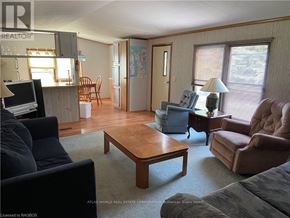 Northern Bruce Peninsula mobile home for rent - A living room with a couch, chair, and coffee table.