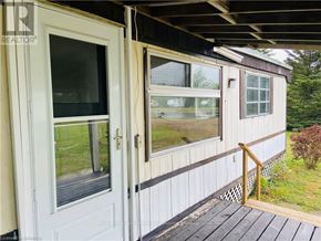 Northern Bruce Peninsula mobile home for rent - A white door and window on a house with a wooden deck.