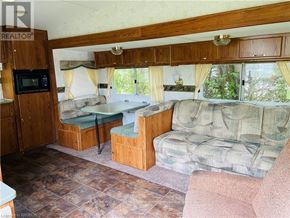 Northern Bruce Peninsula mobile home for rent - A living room with a couch, chair, and a microwave.