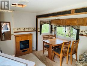 Northern Bruce Peninsula mobile home for rent - A living room with a fireplace and a dining table.