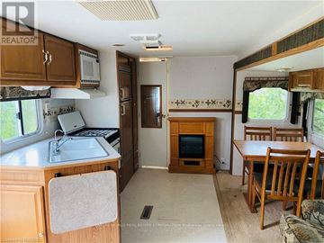 Northern Bruce Peninsula mobile home for rent - A kitchen area with a sink, microwave, and a refrigerator.