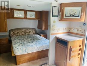 Northern Bruce Peninsula mobile home for rent - A bedroom with a bed, a cabinet, and a counter.