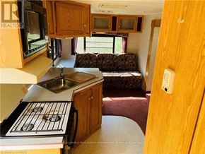 Northern Bruce Peninsula mobile home for rent - A kitchen area with a stove, sink, and microwave.