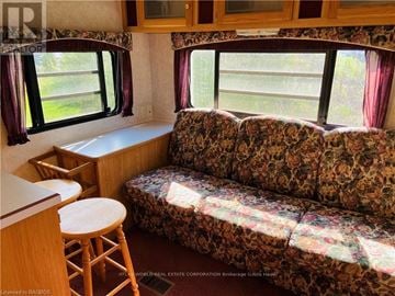 Northern Bruce Peninsula mobile home for rent - A living room with a couch and a stool.