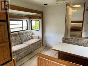Northern Bruce Peninsula mobile home for rent - A living room with a couch, a table, and a window.