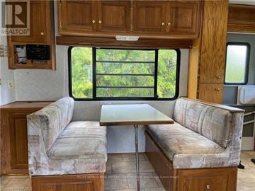 Northern Bruce Peninsula mobile home for rent - A living room with a couch and a table in front of a window.