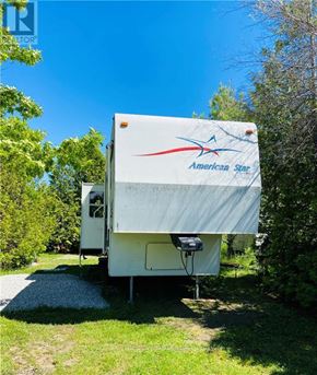 Northern Bruce Peninsula mobile home for rent - An American Star RV is parked in a grassy area.