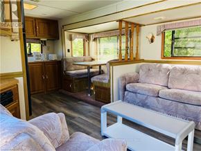 Northern Bruce Peninsula mobile home for rent - A living room with a couch, a table, and a window.