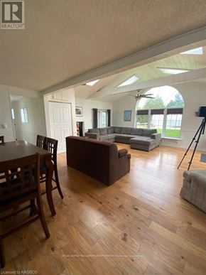 Northern Bruce Peninsula mobile home for rent - A living room with a brown couch and a wooden dining table.