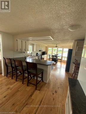 Northern Bruce Peninsula mobile home for rent - A kitchen with wooden floors and white walls.