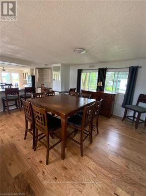 Northern Bruce Peninsula mobile home for rent - A dining room with a wooden table and chairs.