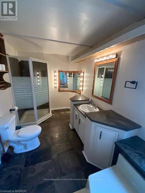 Northern Bruce Peninsula mobile home for rent - A bathroom with a toilet, sink, and mirror.