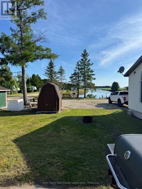 Northern Bruce Peninsula mobile home for rent - A backyard with a grill and a shed.