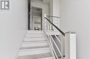 Toronto (Bathurst Manor) triplex for rent - A staircase with a metal railing and a carpeted runner.