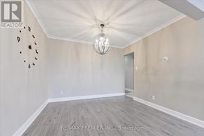 Toronto (Bathurst Manor) triplex for rent - A large empty room with a chandelier and a wall of black objects.