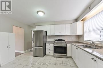 Toronto (Bathurst Manor) triplex for rent - A kitchen with white cabinets and a stainless steel refrigerator.