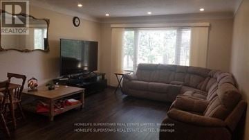 Niagara Falls (Clifton Hill) house for rent - A living room with a brown couch and a flat screen TV.