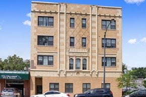 Chicago apartment for rent - a large brick building with cars parked in front of it