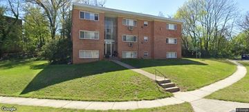 Suitland apartment for rent - A red brick apartment building with a green lawn in front.