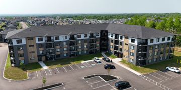Dieppe apartment for rent - A large apartment complex with a parking lot in front.